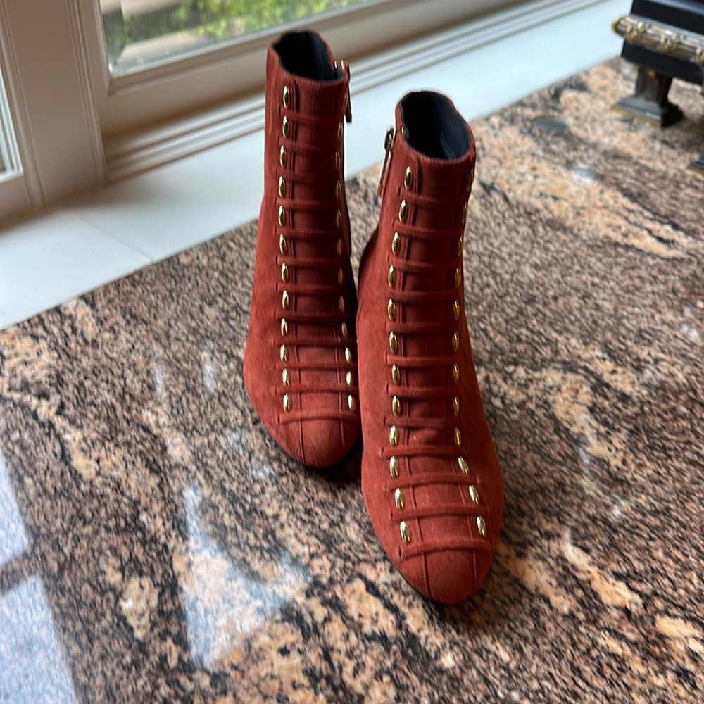 A fantastic pair of orange dude boots with gold accessories.
